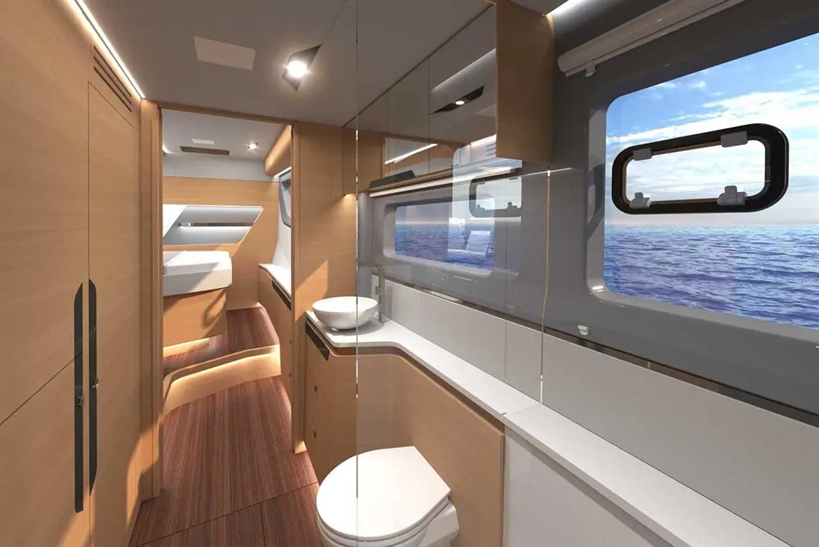 Modern boat bathroom featuring wooden cabinets, basin, toilet, large windows with ocean view, and ambient lighting.